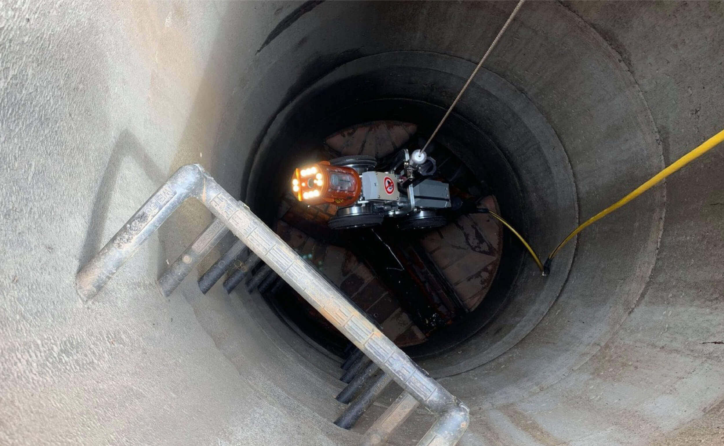 Pipe inspection robot being lowered into sewer